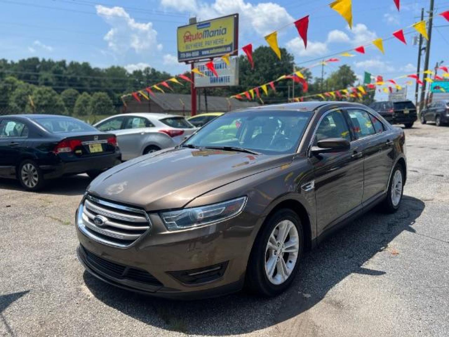 2015 Brown Ford Taurus SEL FWD (1FAHP2E88FG) with an 3.5L V6 DOHC 24V engine, 6-Speed Automatic transmission, located at 1806 Veterans Memorial Hwy SW, Austell, GA, 30168, (770) 944-9558, 33.817959, -84.606987 - Photo#0